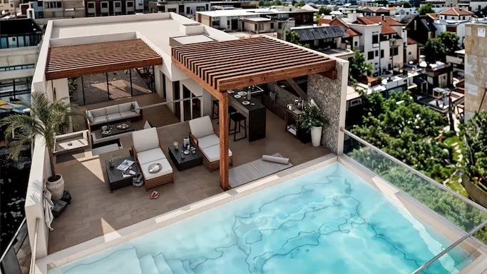Aerial view of the private rooftop pool and lounging area in a downtown Playa del Carmen condo.